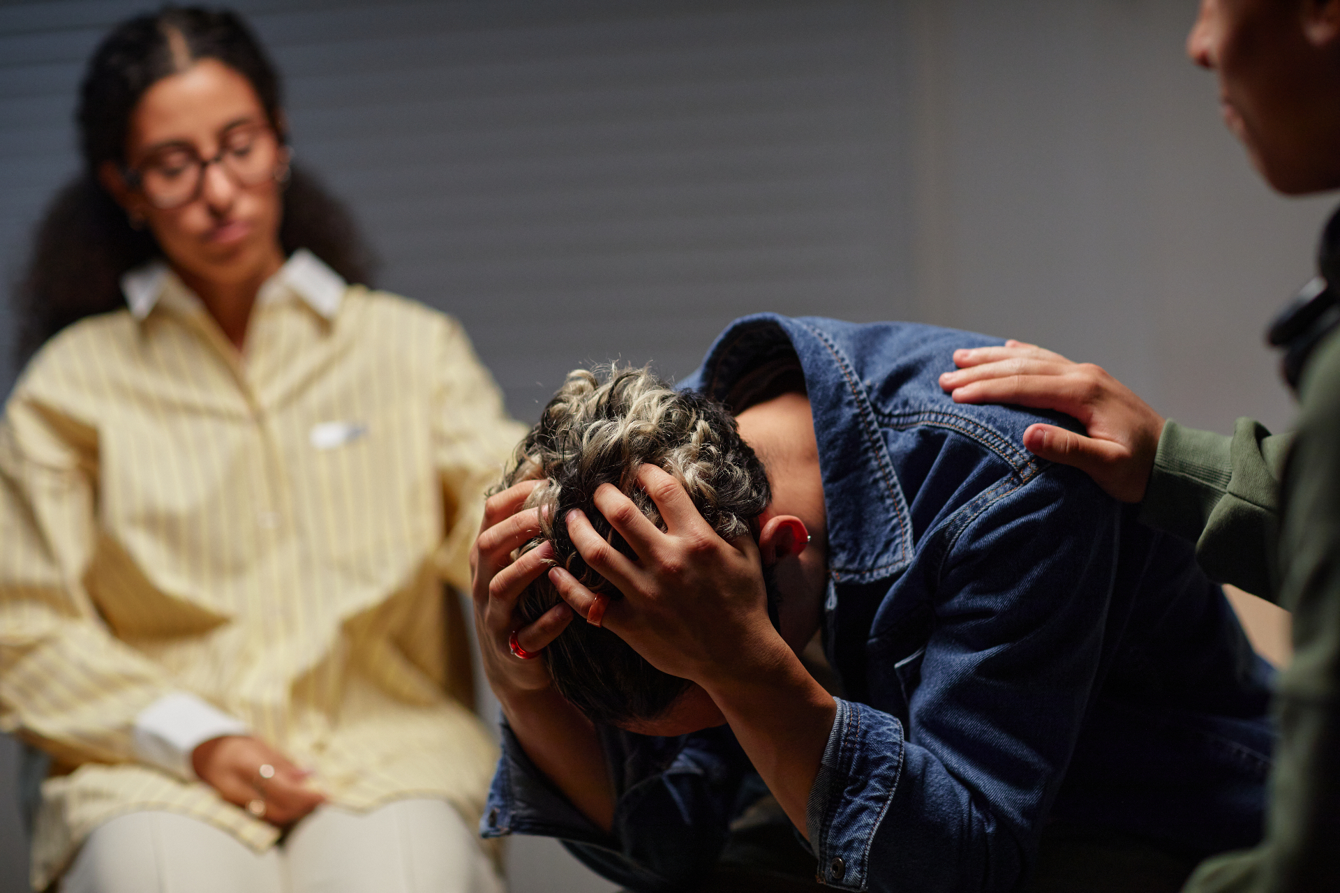 Therapy room with counsellor and client in silent pain